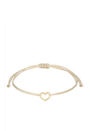 Bracelet réglable en cordon beige avec un petit pendentif cœur ouvert doré au centre et fermeture à nœud coulissant.