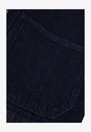Dunkelblaues Denim-Material mit einer glatten Textur, versehen mit einer Tasche mit kontrastierenden Nähten und einem subtilen Glanz, der einen klassischen Look erzeugt.
