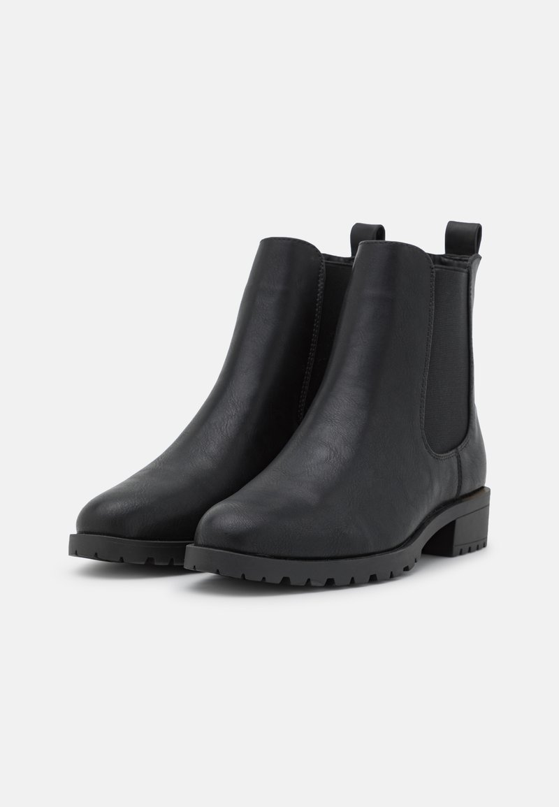 Botas de tobillo de cuero negro con paneles laterales elásticos, puntera redondeada y un tacón bajo tipo bloque. Presentan una suela de goma con patrón para mejorar la tracción.
