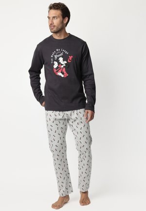 Camisa de pijama negra de manga larga con estampado gráfico; pantalones de pijama grises con un patrón de dibujos animados repetido; tejido suave, corte relajado.