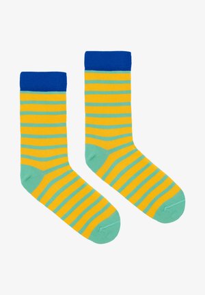 Skarpetki w paski w kolorach żółtym, zielonym i niebieskim. Wykonane z miękkiego materiału, z ribbowanym niebieskim mankietem i jednolitym zielonym palcem.