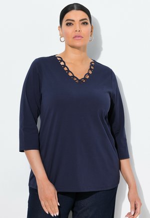 Navyblauw V-hals top met scalloped uitsnijdingen bij de halslijn en driekwart mouwen, gemaakt van lichte, soepele stof.