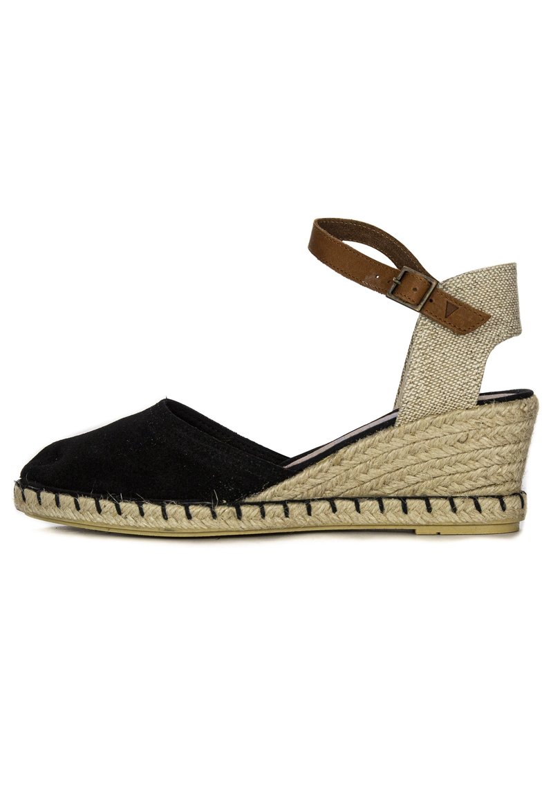 Espadrilles de lona negra con cuña, tira de tela beige en el tobillo y detalle de yute trenzado alrededor de la suela. Cierre con hebilla ajustable.