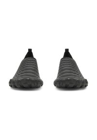 Scarpe slip-on nere con motivo ondulato e testurizzato, materiale flessibile e suola robusta per trazione. Dotate di linguette posteriori per facilitare la calzata.
