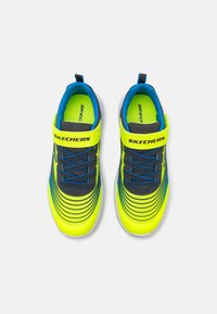Des chaussures Skechers avec un dessus jaune néon, des accents bleus, des détails gris et un design rayé. Comprend une sangle Velcro et des lacets.
