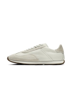 Biały niski sneaker z teksturowaną skórą i nakładkami z zamszu, wiązany, z brązową gumową podeszwą, pokazany z boku na białym tle.