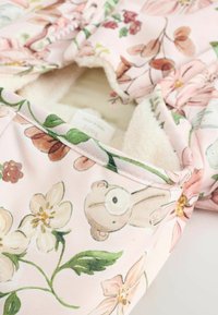 Õrnroosast lillemustriga kangas, millel on teddykaru ja lillekujundused. Sisaldab hubast valget fliisvoodrit ja elastset äärt.