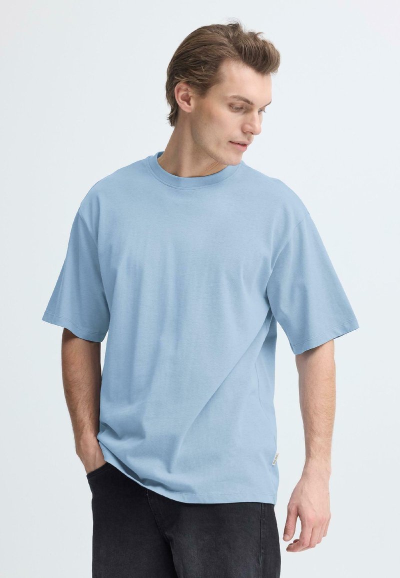 Svetlomodré bavlnené tričko s krátkymi rukávmi a okrúhlym výstrihom, s priamym strihom a jemným detailom na bočnej značke.
