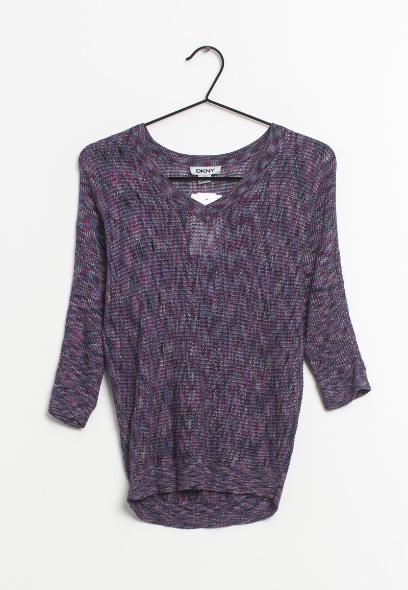 Pull-over en V tricoté violet, noir et rose avec des manches trois-quarts suspendu sur un cintre noir, sur un fond blanc.