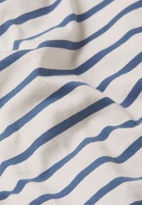 Tejido de algodón con rayas horizontales en azul y blanco, de textura suave, ligeramente arrugado, que exhibe un diseño informal.