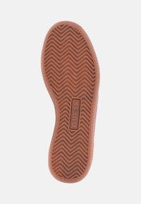 Sole de cauciuc pentru pantofi, de culoare piersică deschisă, având un model în zigzag pentru aderență, cu un logo central embosat într-o formă rectangulară.