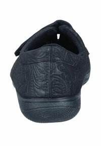 Black slip-on shoe with textured floral pattern on the upper, Velcro strap, and a rubber sole. Rear view showing design and structure.