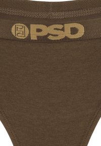 Smeđe pamučne tangice s bež elastičnom gumicom na kojoj se nalazi logo "PSD" u podebljanom fontu. Glatka tkanina i bešavna izrada.