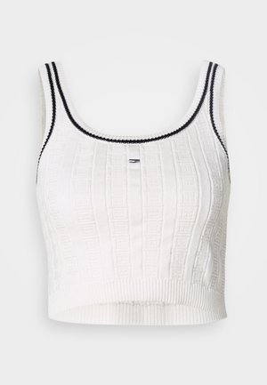 Top corto bianco con motivo a maglia strutturata, bordatura nera al girocollo e alle maniche, e silhouette aderente.