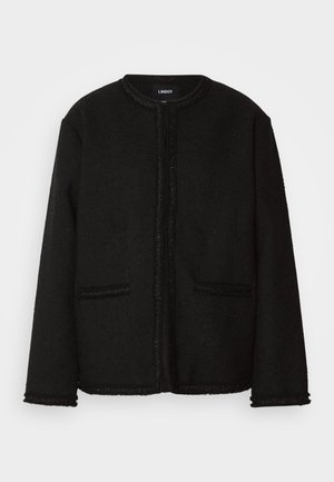 Black jacket made of textured fabric with a round neckline, front pockets, and a fringed trim along the edges and cuffs.