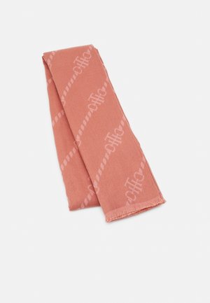 Écharpe rose poudré pliée avec un motif monogramme répétitif subtil et des franges courtes à une extrémité, sur fond blanc.