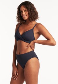 Marineblauw bikini set met een wikkelstijl bovenstuk en hoge taille onderstuk. Gladde textuur, dunne banden en minimale ontwerpelementen.