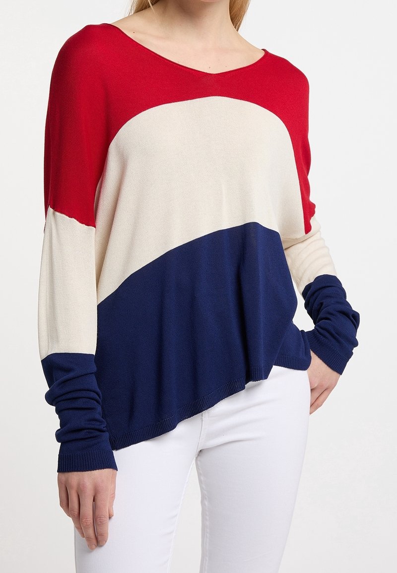 Pull en maille coloré en rouge, crème et marine, avec un col en V, des manches longues et une coupe décontractée, doté de poignets et d'un ourlet côtelés.