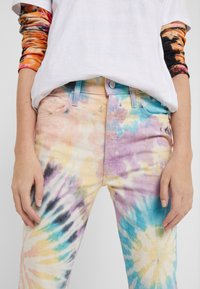 Multicolore tie-dye spijkerbroek met pastelkleuren in roze, blauw, geel en zwart, met een knoopsluiting en voorzakken.