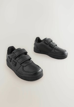 Melnas sintētiskas kurpes ar diviem regulējamajiem Velcro siksnām, noapaļota purngalu, teksturētu zoli, gludu augšdaļu un iepludinātiem dzīvnieku motīviem sānos.