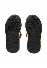 Płaskie obuwie z gumową, teksturowaną podeszwą w kolorze czarnym, zdobioną wzorem w strukturze plastra miodu oraz brązowymi akcentami po bokach.