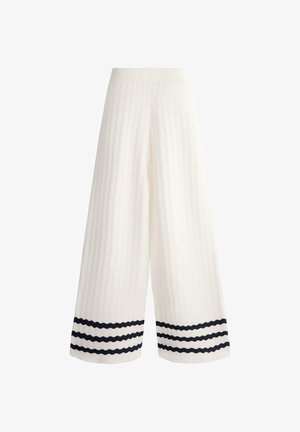 White wide-leg knit pants with textured wave pattern and three black horizontal stripes near the hem on each leg.