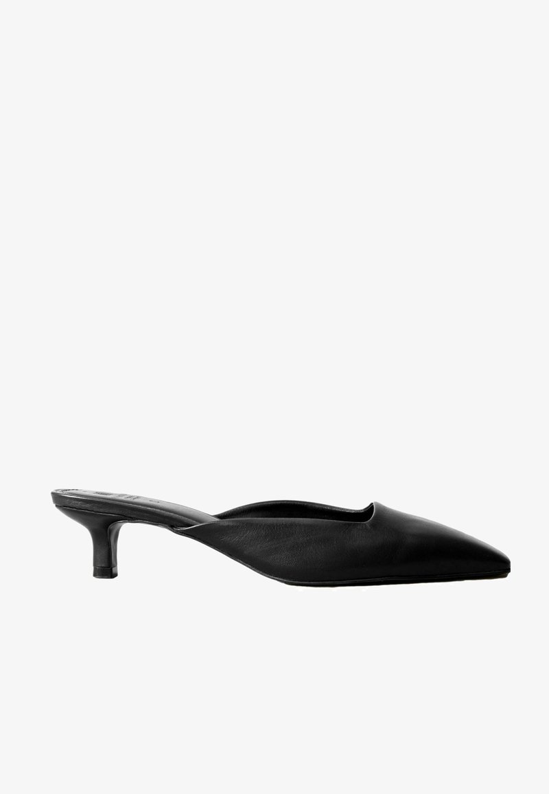 Mules en cuir noir à talon avec un bout pointu, un dos ouvert et un talon bas en bloc. Texture lisse avec un design minimaliste.