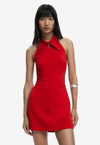 Red sleeveless dress with a high collar, featuring a front zipper and a fitted silhouette. Smooth texture, minimalistic design, and sleek accents.