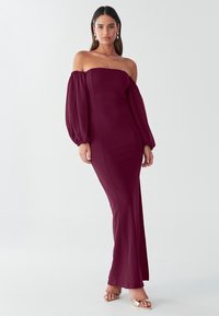 Bordo obleka brez ramen z dolgimi napihnjenimi rokavi in oprijeto silhueto, izdelana iz gladkega blaga, z dolgo do tal segajočo zasnovo.