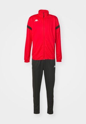 Veste de sport rouge avec des accents noirs et fermeture éclair, associée à un pantalon noir. Les deux sont fabriqués en matériau léger et lisse. Logo Kappa présent.