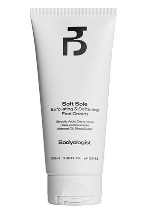 Tube en plastique blanc de crème pour les pieds, avec un logo noir, et un texte noir indiquant les ingrédients et les détails du produit. Taille de 100 ml.