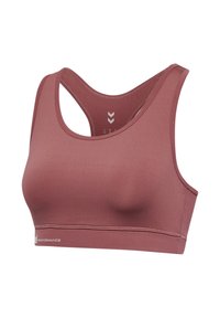 Sports bra in muted rose color, made of smooth, stretchy fabric. Features a racerback design and subtle branding on the band.