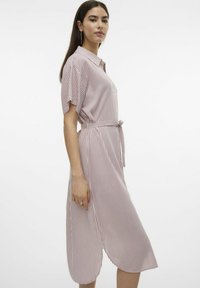 Vestido rayado en rosa claro y blanco, con mangas cortas, parte delantera abotonada, cinturilla ajustable, de longitud media, con una abertura lateral para mayor comodidad al moverse.