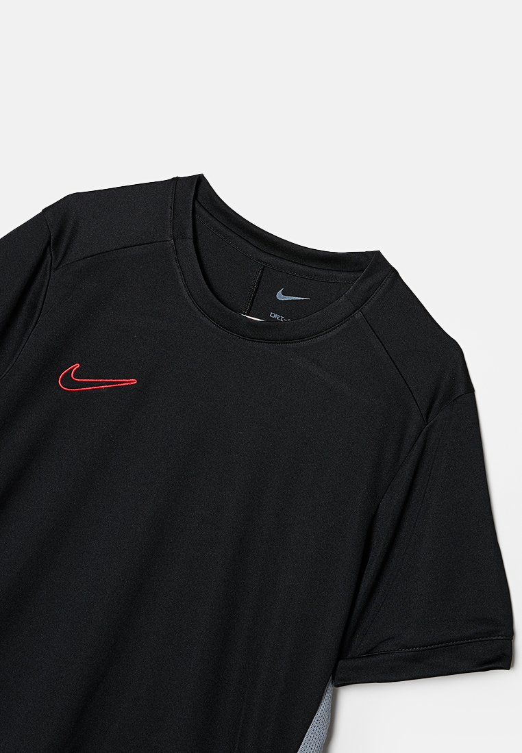 Camiseta deportiva Nike Dri-FIT negra de mangas cortas, con cuello redondo, logotipo Swoosh rojo en el pecho y detalles de malla gris en los laterales.