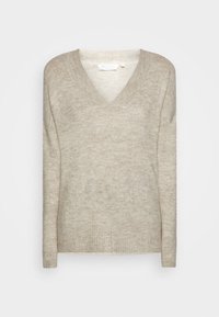 Beżowy sweter z dekoltem w serek o miękkiej fakturze, z prążkowanymi mankietami i dołem oraz luźnym krojem. Wykonany z lekkiego, przytulnego materiału z delikatnym wzorem.