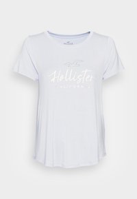 Jasnoniebieska koszulka z krótkim rękawem, wykonana z miękkiego materiału, z białym nadrukiem logo "Hollister California" i grafiką mewy.