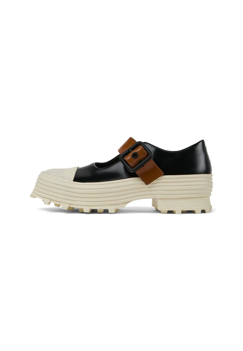Chaussure en cuir verni noir avec une semelle crême striée et un détail de boucle marron. Présente un bout arrondi et un dessus texturé pour une meilleure adhérence.