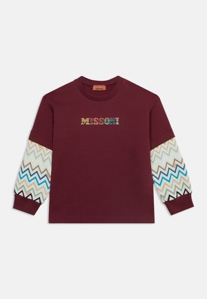 Meripunainen pyöreäkauluksinen collegepaita, jossa moniväriset siksak-kuviolliset pitkät hihat ja monivärinen "MISSONI"-logo rinnan keskellä.