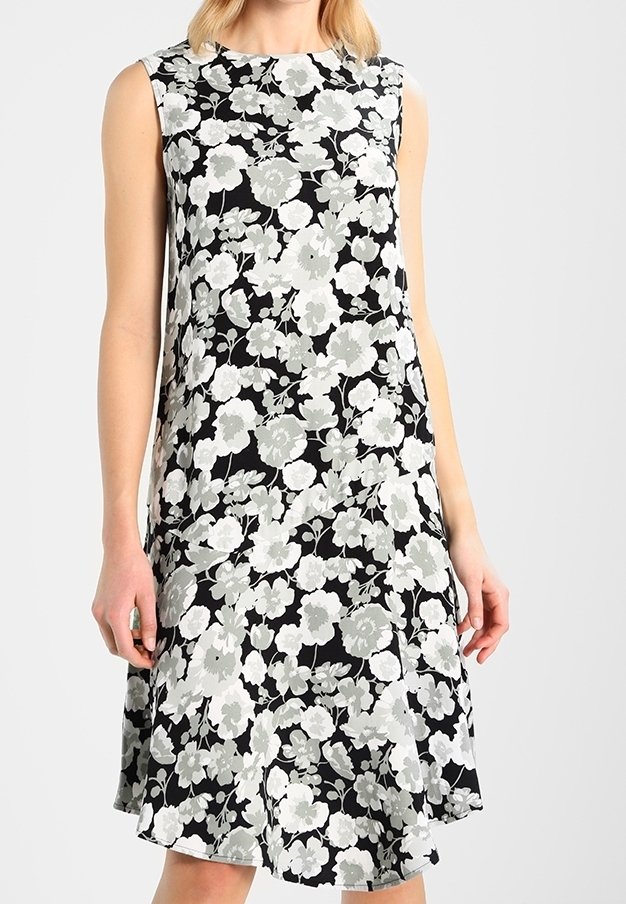 Černé šaty bez rukávů s květinovým vzorem v odstínech šedé a bílé, volného střihu a rozšířeným lemem. Měkká textilie.