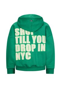 Felpa verde con cappuccio realizzata in morbido materiale, caratterizzata da un audace testo in rilievo bianco: "SHOP TILL YOU DROP IN NYC." Cappuccio con coulisse e polsini a coste.