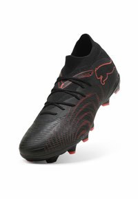 Μαύρο και κόκκινο ποδοσφαιρικό παπούτσι με πλεκτό κολάρο στον αστράγαλο, κορδόνια, υφασμένο συνθετικό πάνω μέρος και υποστήριξη με τάπες στην σόλα.