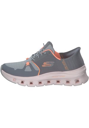 Sportlicher Schuh mit grauem Mesh-Obermaterial, rosa Akzenten und einer gepolsterten Sohle mit Ausschnitten für Luftzirkulation. Leichtes Design, flexibles Material.
