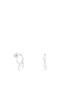 Pendientes de aro de plata presentan un charm en forma de corazón y un charm de oso colgante con un acento de perla, mostrando un acabado pulido y un diseño intrincado.