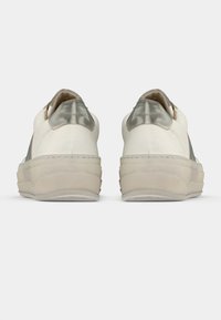 White leather sneakers with a metallic grey accent at the heel, thick cream-colored sole, and stitched detailing along the sides.