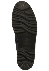 Musta kuminuljas, jossa on aaltoileva pintakuvio, kohokuvioitu Gabor-logo ja teksturoitu yksityiskohta reunassa. Kestävä ja toiminnallinen muotoilu.