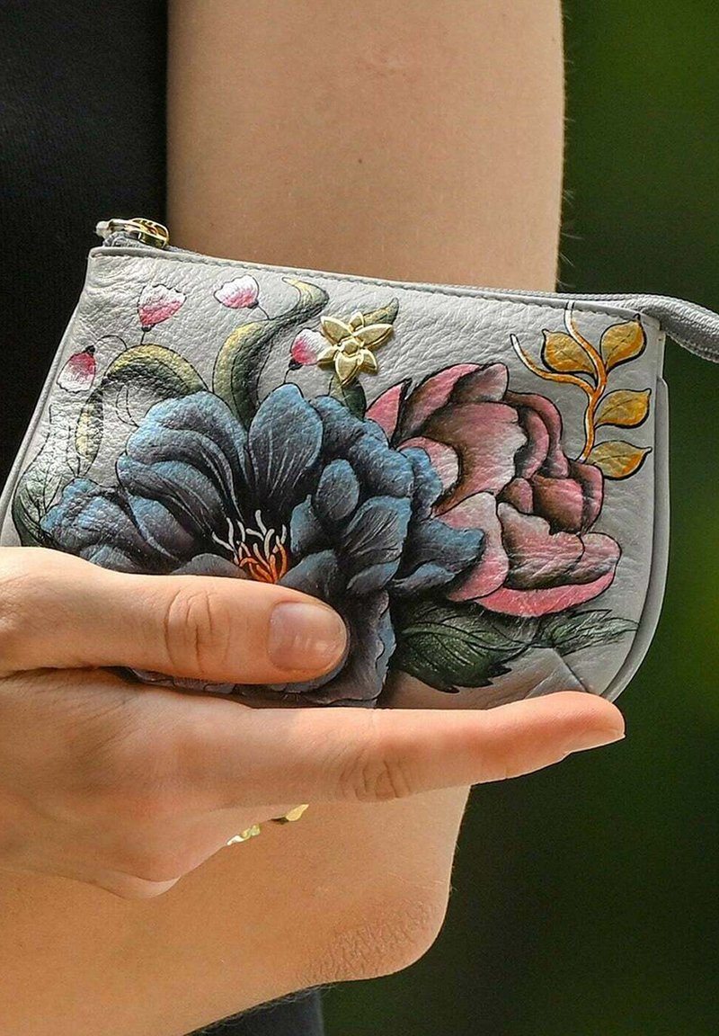 Grijze lederen pouch met kleurrijke bloemenpatronen in blauw, roze en groen. Inclusief een gouden accent en ritssluiting. Compact en textuur.