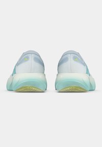 Zapatillas deportivas azul claro con una parte superior texturizada, detalles en verde y una suela blanca gruesa. Presentan tres franjas azules en los lados.