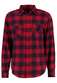 Camisa de franela a cuadros en rojo y azul marino con botones al frente, dos bolsillos en el pecho y mangas largas. Confeccionada en una tela suave y texturizada.