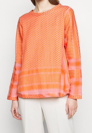 Langärmliges oranges Oberteil mit einem strukturierten Muster und geometrischen Designs, runder Halsauschnitt und kontrastierenden pinken Akzenten.