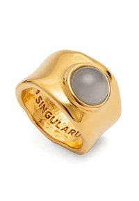 Anillo de metal en tono dorado con un diseño liso y redondeado que presenta una gema gris central. Interior grabado con la palabra "SINGULAR."